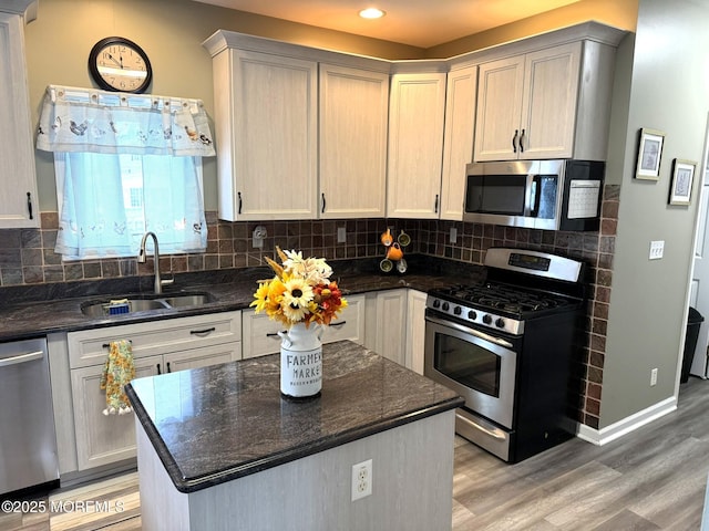 128 E Delaware Dr, Little Egg Harbor, NJ 08087 - kitchen featuring stainless steel appliances, a sink, light wood-type flooring, decorative backsplash, and a kitchen island