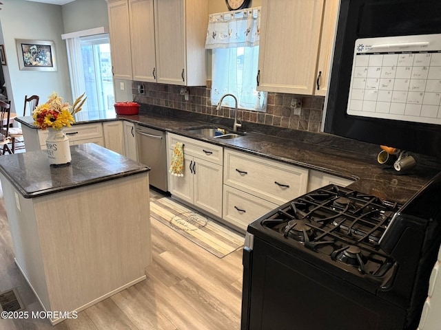 128 E Delaware Dr, Little Egg Harbor, NJ 08087 - kitchen featuring black gas range oven, stainless steel dishwasher, a sink, light wood finished floors, and tasteful backsplash