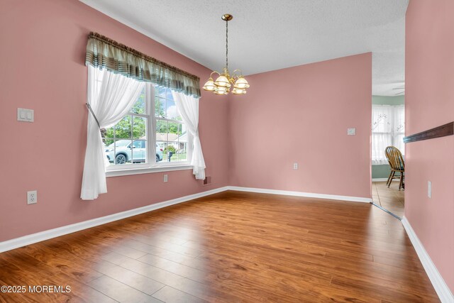4 Beechwood Ct, Barnegat, NJ 08005 - empty room with a chandelier, plenty of natural light, wood finished floors, baseboards, and a textured ceiling