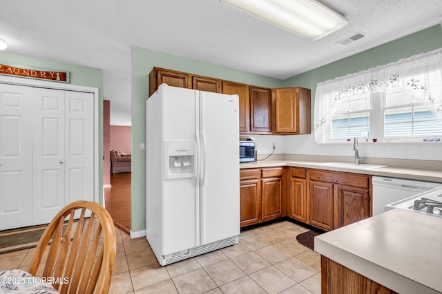 4 Beechwood Ct, Barnegat, NJ 08005 - kitchen featuring white appliances, a sink, brown cabinets, light tile patterned floors, and a textured ceiling