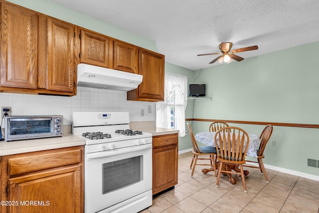 4 Beechwood Ct, Barnegat, NJ 08005 - kitchen with white range with gas stovetop, under cabinet range hood, a ceiling fan, decorative backsplash, and light countertops