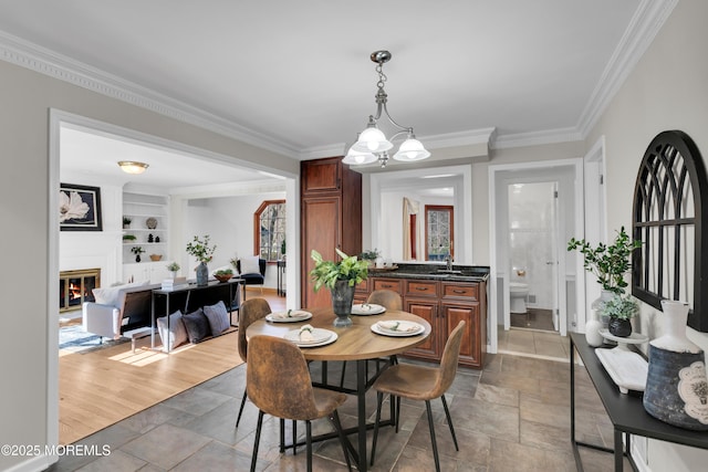 160 Pelican Rd, Middletown, NJ 07748 - dining room with stone tile flooring, ornamental molding, built in shelves, a glass covered fireplace, and baseboards
