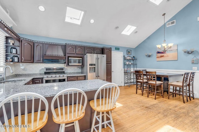 22 Franklin Ave, Hazlet, NJ 07734 - kitchen featuring stainless steel appliances, a sink, premium range hood, open shelves, and a skylight