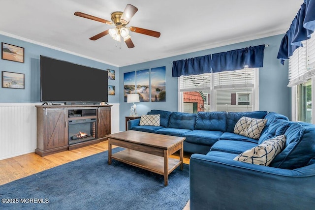 22 Franklin Ave, Hazlet, NJ 07734 - living room with crown molding, light wood finished floors, a ceiling fan, a lit fireplace, and wainscoting