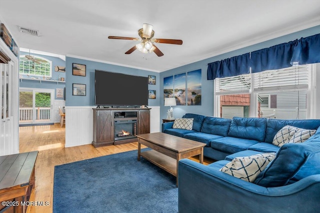 22 Franklin Ave, Hazlet, NJ 07734 - living room featuring ceiling fan, wood finished floors, a warm lit fireplace, ornamental molding, and wainscoting