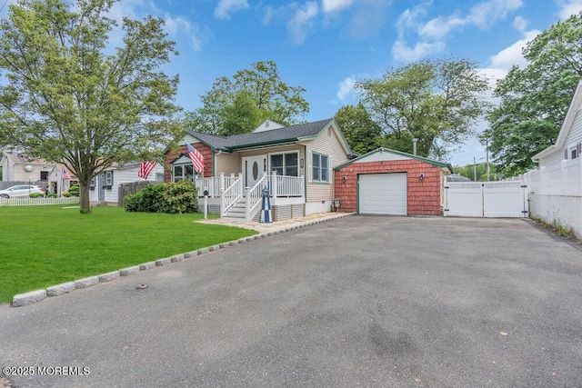 22 Franklin Ave, Hazlet, NJ 07734 - view of front facade with a detached garage, a gate, covered porch, asphalt driveway, and an outdoor structure