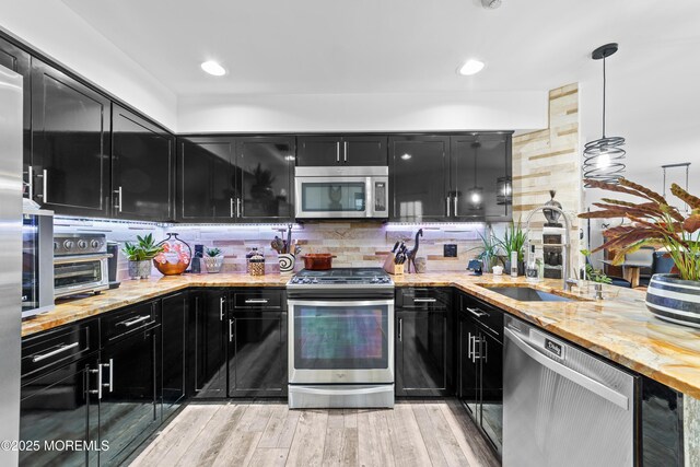 68 Winthrop Rd Unit 68B, Monroe, NJ 08831 - kitchen with dark cabinetry, stainless steel appliances, a sink, backsplash, and light stone countertops