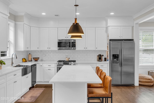 804 Linden Rd, Toms River, NJ 08753 - kitchen featuring appliances with stainless steel finishes, a sink, a kitchen island, wood finished floors, and a kitchen breakfast bar