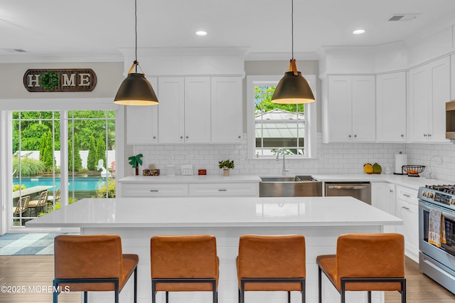 804 Linden Rd, Toms River, NJ 08753 - kitchen with appliances with stainless steel finishes, a sink, light countertops, tasteful backsplash, and a kitchen bar