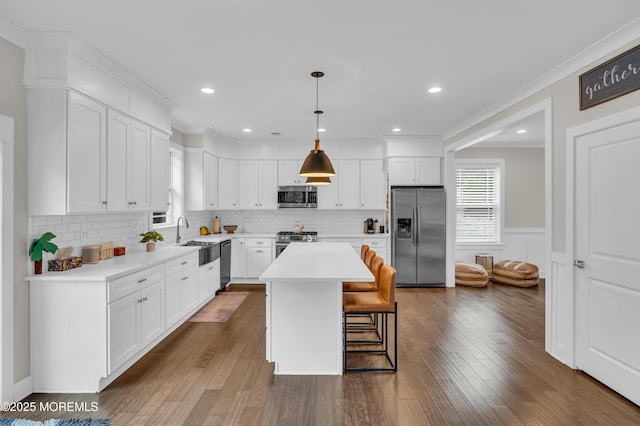 804 Linden Rd, Toms River, NJ 08753 - kitchen with appliances with stainless steel finishes, a sink, a kitchen bar, white cabinetry, and wainscoting