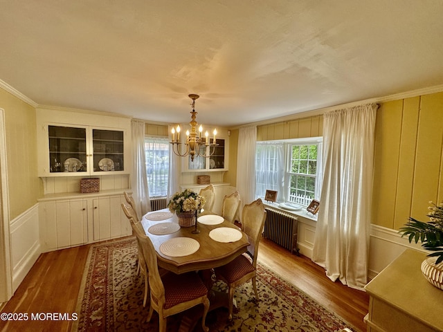 8 Spruce St, Toms River, NJ 08753 - dining area featuring wood finished floors, radiator, a chandelier, ornamental molding, and a decorative wall