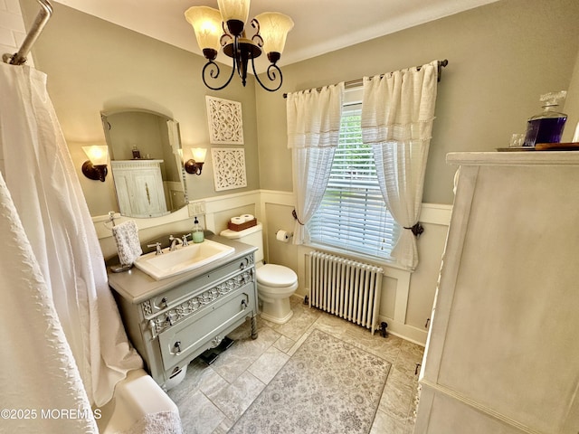 8 Spruce St, Toms River, NJ 08753 - bathroom with radiator heating unit, a chandelier, toilet, vanity, and a wainscoted wall