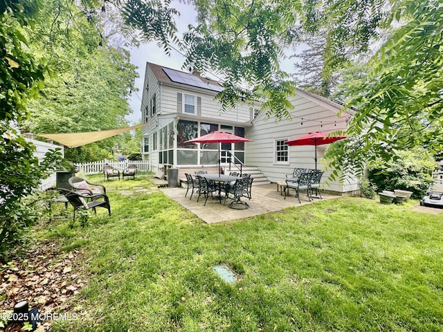8 Spruce St, Toms River, NJ 08753 - rear view of property featuring roof mounted solar panels, a patio area, and a sunroom