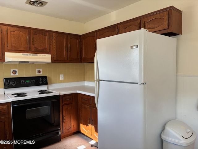 10 Monmouth Ln Unit B, Whiting, NJ 08759 - kitchen featuring electric range, under cabinet range hood, freestanding refrigerator, light countertops, and tasteful backsplash