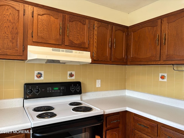 10 Monmouth Ln Unit B, Whiting, NJ 08759 - kitchen featuring electric range oven, under cabinet range hood, backsplash, light countertops, and brown cabinets