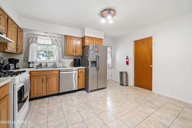 952 Stafford Dr, Toms River, NJ 08753 - kitchen with stainless steel appliances, light countertops, a sink, brown cabinetry, and light tile patterned floors