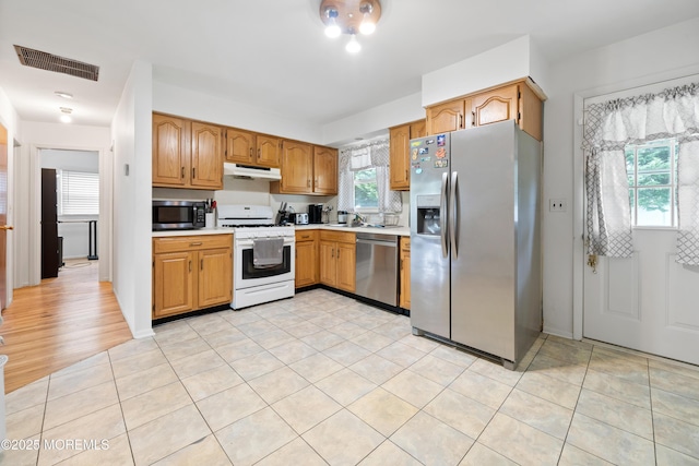 952 Stafford Dr, Toms River, NJ 08753 - kitchen with stainless steel appliances, under cabinet range hood, light countertops, a sink, and light tile patterned floors