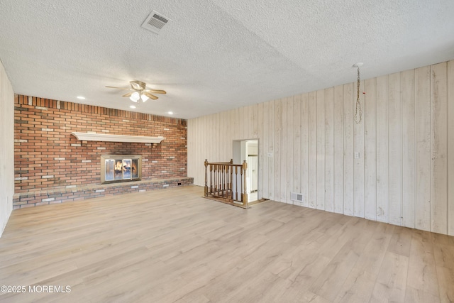 26 Nevada Dr, Hazlet, NJ 07730 - unfurnished living room with a ceiling fan, a textured ceiling, wood finished floors, a brick fireplace, and wooden walls