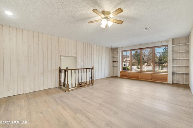 26 Nevada Dr, Hazlet, NJ 07730 - unfurnished room with a textured ceiling, wood finished floors, a ceiling fan, built in features, and wood walls