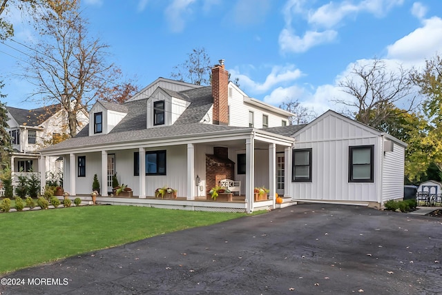 137 Church St, Fair Haven, NJ 07704 - view of front facade with board and batten siding, covered porch, a shingled roof, a front lawn, and a chimney