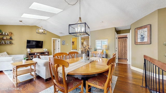 280 Tulip Ln, Freehold, NJ 07728 - dining room featuring dark wood-style flooring, a skylight, a chandelier, lofted ceiling, and baseboards