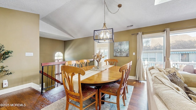 280 Tulip Ln, Freehold, NJ 07728 - dining area with plenty of natural light, a chandelier, dark wood-style floors, a textured ceiling, and vaulted ceiling