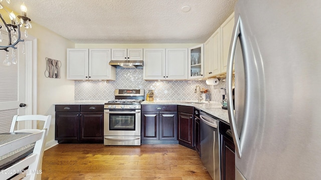 280 Tulip Ln, Freehold, NJ 07728 - kitchen featuring appliances with stainless steel finishes, light wood-style flooring, dark brown cabinets, backsplash, and white cabinets