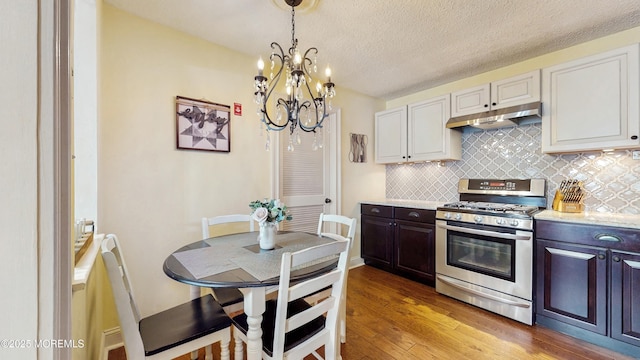 280 Tulip Ln, Freehold, NJ 07728 - kitchen featuring stainless steel range with gas cooktop, under cabinet range hood, light wood finished floors, a chandelier, and tasteful backsplash
