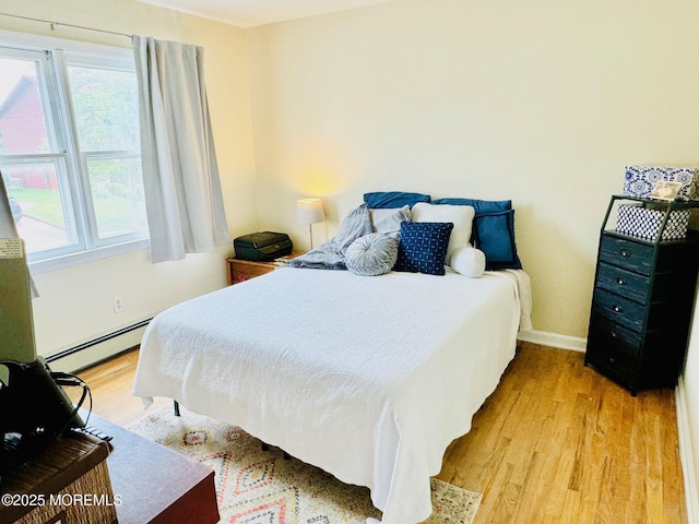 7 Rosewood Dr, Milltown, NJ 08850 - bedroom featuring a baseboard heating unit, light wood-style floors, and baseboards