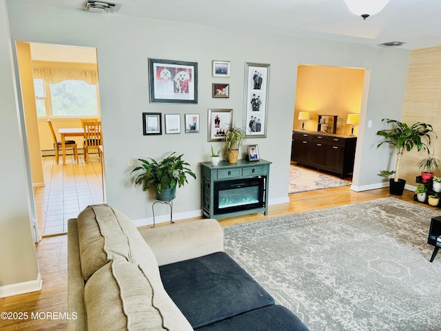 7 Rosewood Dr, Milltown, NJ 08850 - living area with baseboards, light wood finished floors, and a baseboard heating unit