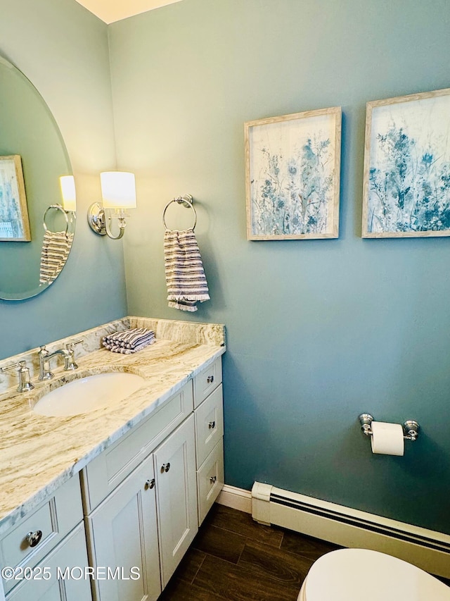 7 Rosewood Dr, Milltown, NJ 08850 - bathroom with baseboard heating, vanity, wood finished floors, baseboards, and toilet