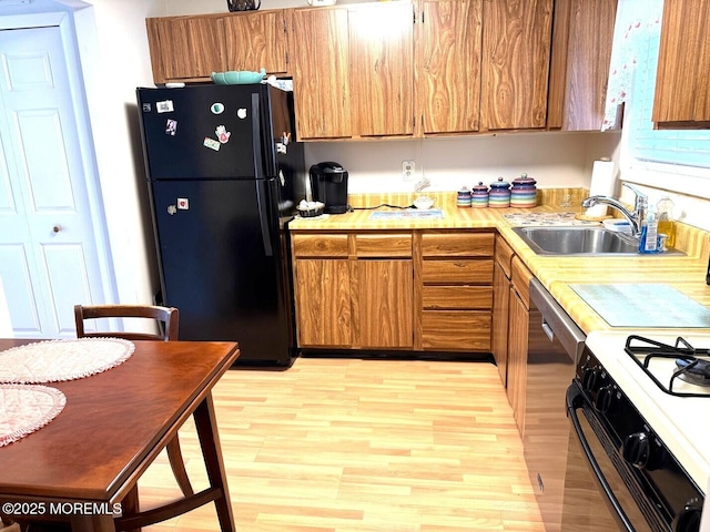 132 Seaview Ave, Brick, NJ 08723 - kitchen with freestanding refrigerator, light wood-style floors, light countertops, brown cabinetry, and a sink