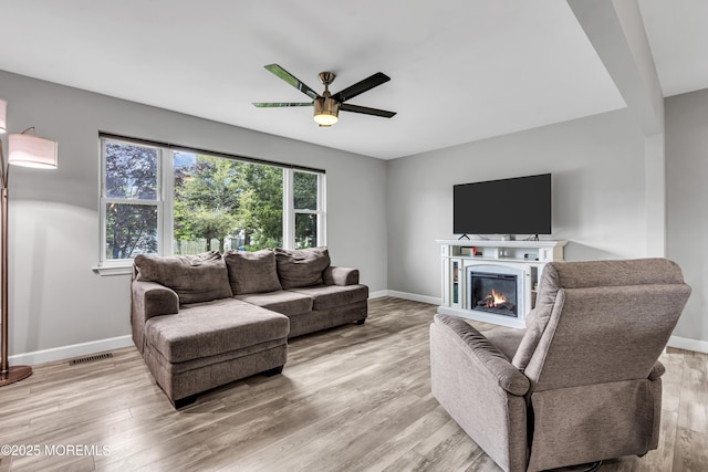120 Lake Winnepesaukee Dr, Little Egg Harbor, NJ 08087 - living room featuring a ceiling fan, baseboards, light wood finished floors, and a glass covered fireplace