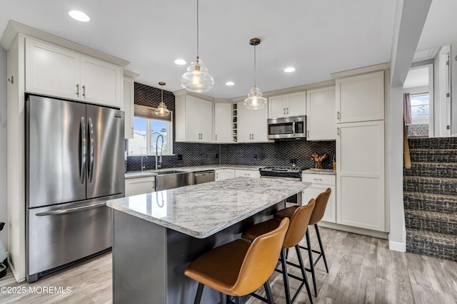 120 Lake Winnepesaukee Dr, Little Egg Harbor, NJ 08087 - kitchen featuring appliances with stainless steel finishes, light wood-style floors, a kitchen island, tasteful backsplash, and light stone countertops