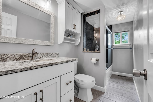 120 Lake Winnepesaukee Dr, Little Egg Harbor, NJ 08087 - bathroom with vanity, baseboards, toilet, wood finished floors, and combined bath / shower with glass door