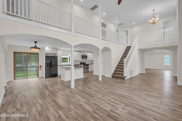 352 Leesville Rd, Jackson, NJ 08527 - unfurnished living room featuring a towering ceiling, ornate columns, light wood-style flooring, healthy amount of natural light, and recessed lighting