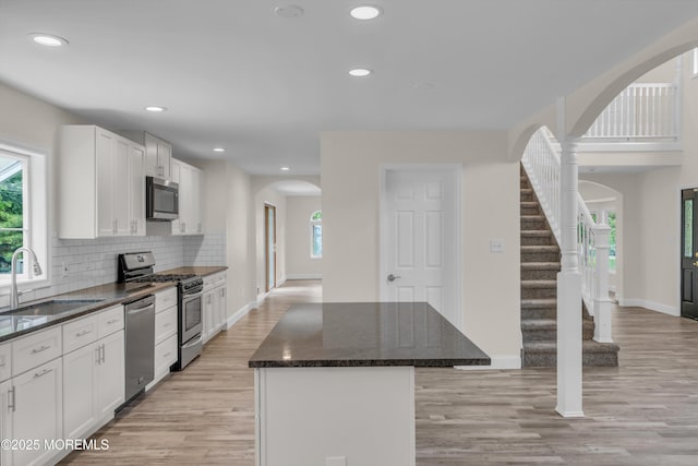 352 Leesville Rd, Jackson, NJ 08527 - kitchen with a sink, stainless steel appliances, arched walkways, a kitchen island, and baseboards