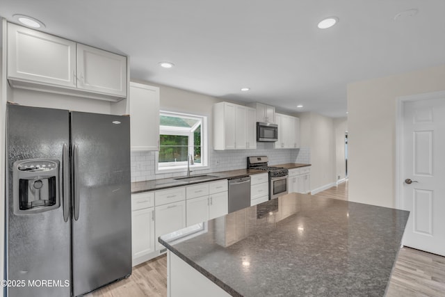 352 Leesville Rd, Jackson, NJ 08527 - kitchen with stainless steel appliances, a sink, light wood finished floors, a center island, and backsplash