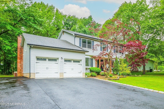 25 Merritt Ter, Matawan, NJ 07747 - view of front of home featuring driveway, an attached garage, a front yard, and a chimney