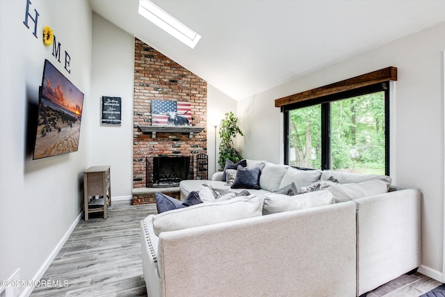 25 Merritt Ter, Matawan, NJ 07747 - living area featuring a fireplace, a skylight, light wood-type flooring, baseboards, and high vaulted ceiling