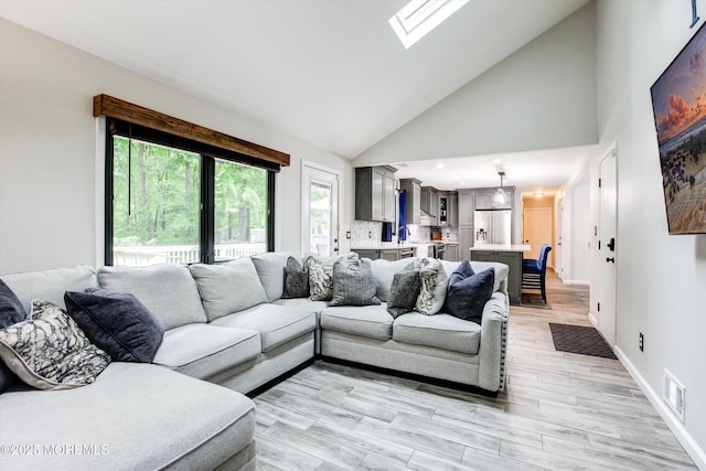 25 Merritt Ter, Matawan, NJ 07747 - living area with a skylight, light wood finished floors, high vaulted ceiling, and baseboards