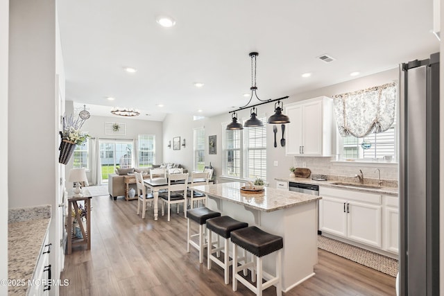 21 Gulfstream Rd, New Egypt, NJ 08533 - kitchen featuring a sink, freestanding refrigerator, white cabinetry, open floor plan, and light stone countertops