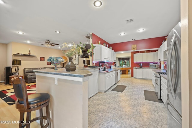 639 Eltone Rd, Jackson, NJ 08527 - kitchen with appliances with stainless steel finishes, a kitchen breakfast bar, a peninsula, recessed lighting, and white cabinetry