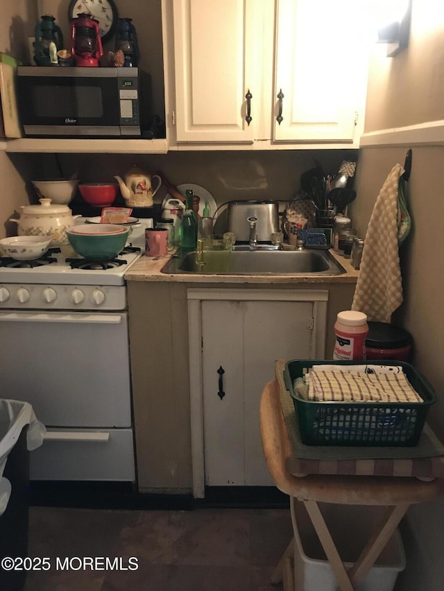 289 Port Monmouth Rd, North Middletown, NJ 07748 - kitchen featuring white gas range, a sink, white cabinetry, and light countertops