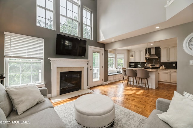 40 Dickerson Ln, Old Bridge, NJ 08857 - living room with light wood finished floors, a towering ceiling, a premium fireplace, and recessed lighting