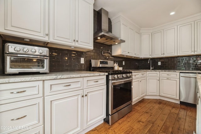 40 Dickerson Ln, Old Bridge, NJ 08857 - kitchen featuring wall chimney exhaust hood, stainless steel appliances, white cabinets, light wood-type flooring, and decorative backsplash