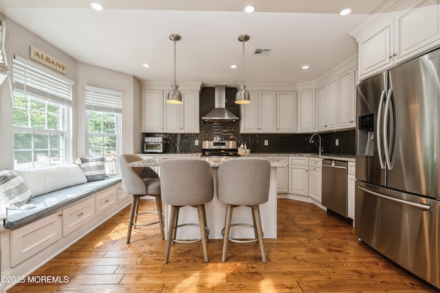 40 Dickerson Ln, Old Bridge, NJ 08857 - kitchen with appliances with stainless steel finishes, wall chimney range hood, tasteful backsplash, light wood finished floors, and a kitchen island