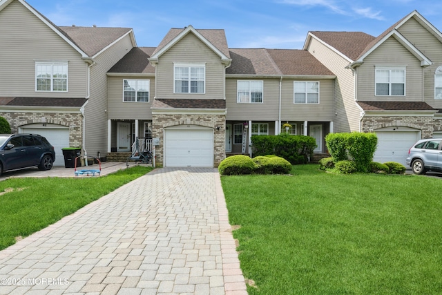 40 Dickerson Ln, Old Bridge, NJ 08857 - townhome / multi-family property featuring decorative driveway, a front lawn, an attached garage, and stone siding