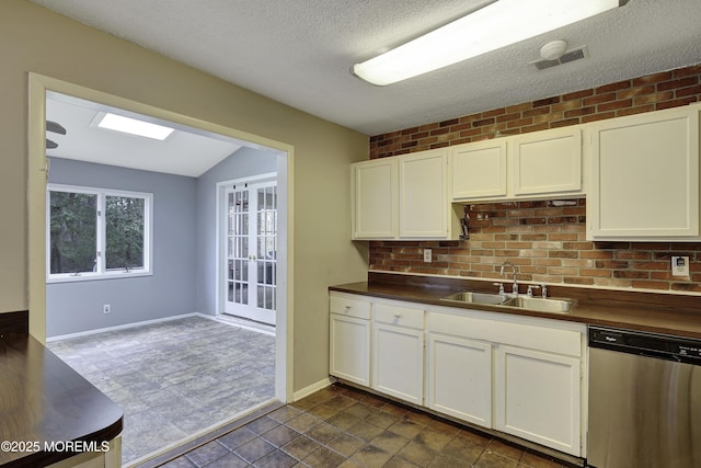 1299 E County Line Rd, Lakewood, NJ 08701 - kitchen with stainless steel dishwasher, a sink, white cabinets, a textured ceiling, and baseboards