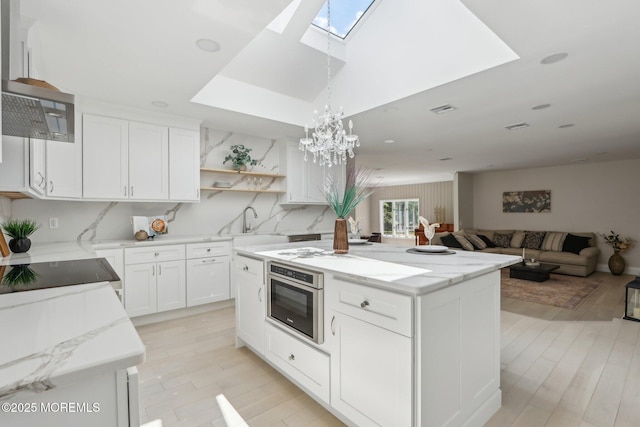 8 Olden Ct, Colts Neck, NJ 07722 - kitchen with a skylight, range hood, a kitchen island, open shelves, and light stone countertops